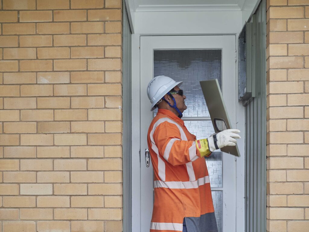 Person inspecting a power meter connected to the Northpower network